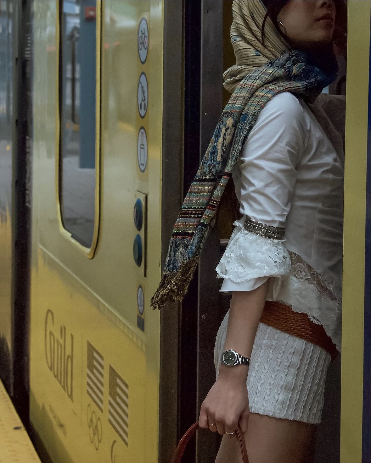 Model stepping into a Metro train in a layered white look