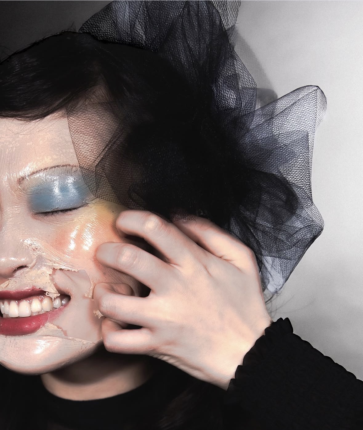 Close-up portrait with glossy makeup and sculptural black tulle